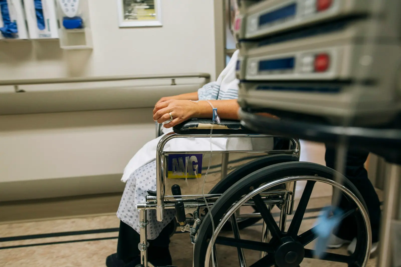 A patient seated in a wheelchair in a hospital room, waiting for a ride home